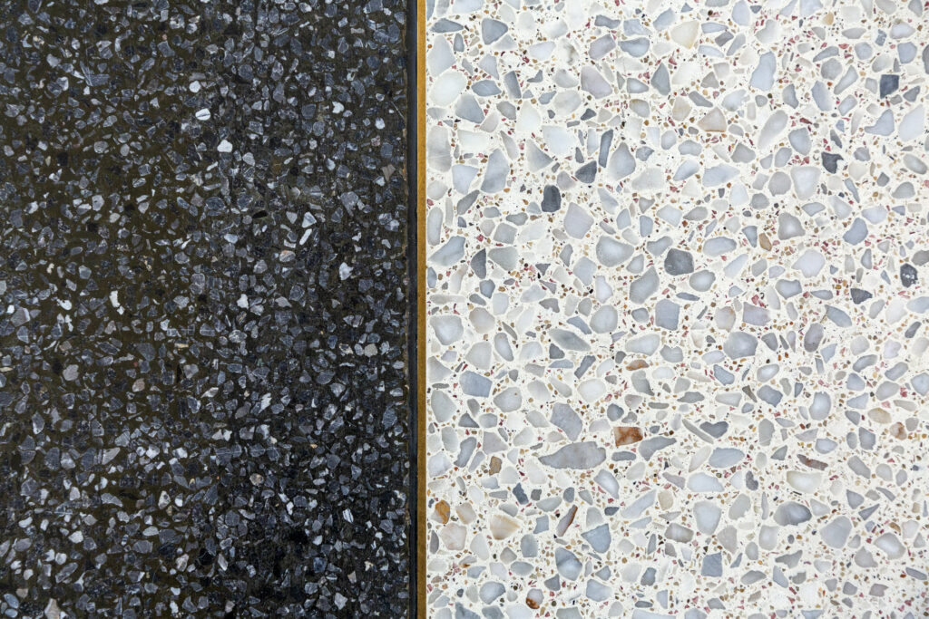 Nieuwe terrazzo gietvloer in kunsthars sluit naadloos aan op originele cementgebonden terrazzo vloer met messing overgangsprofiel