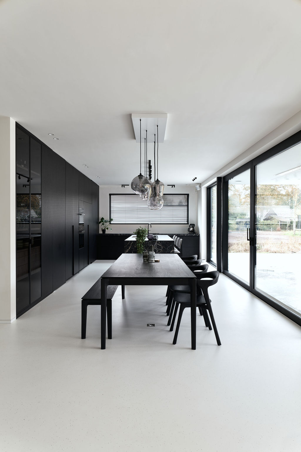 Luxueuze PU gietvloer in een high-end keuken en eetkamer met overvloedige natuurlijke lichtinval, naadloos en stijlvol afgewerkt.