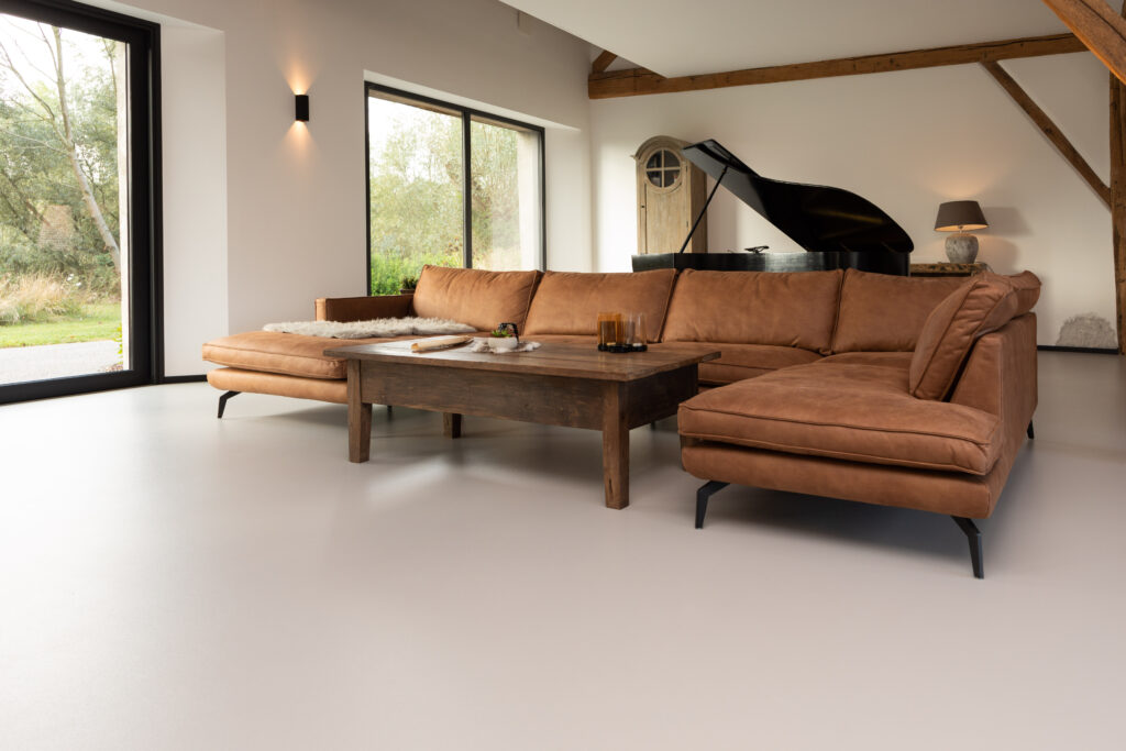 Naadloze gietvloer in authentiek interieur – Een onderhoudsvriendelijke PU gietvloer die de balans tussen oud en nieuw versterkt in een landelijke renovatie.