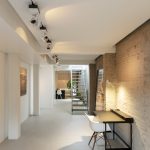 Detail van Mineral Touch gietvloer tegen ruwe bakstenen muur in gerenoveerde loft in Antwerpen.