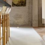 Keukeneiland met barkrukken op Mineral Touch gietvloer in moderne woonruimte.