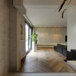 Overgang van Mineral Touch gietvloer naar visgraatparket in moderne leefruimte.