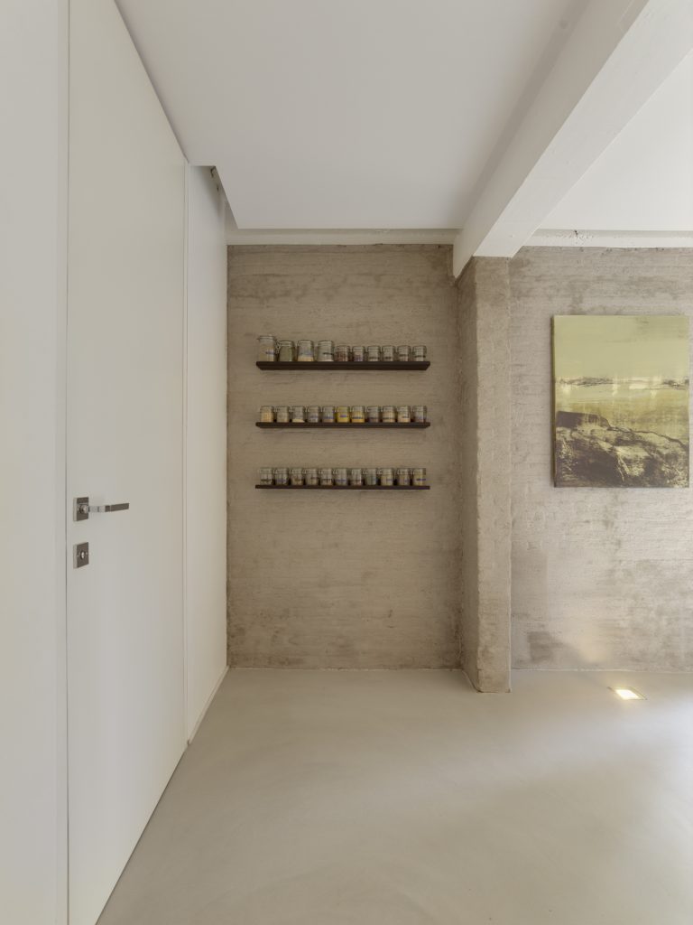 Detail van wandplanken met kruidenpotjes boven Mineral Touch gietvloer.