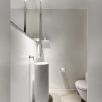 Minimalistische toiletruimte met Mineral Touch vloer en witte wandafwerking.