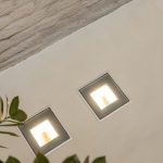 Detail van ingebouwde vloerlichten in Mineral Touch gietvloer naast bakstenen muur.