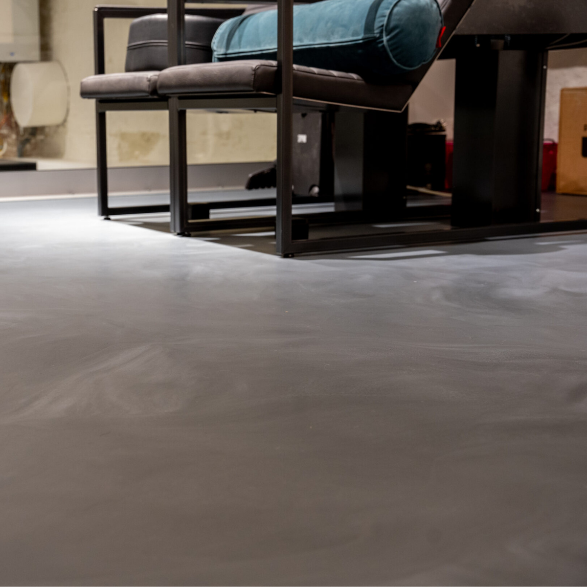 Warme PU gietvloer met betonlook in een stijlvolle leefruimte met haard