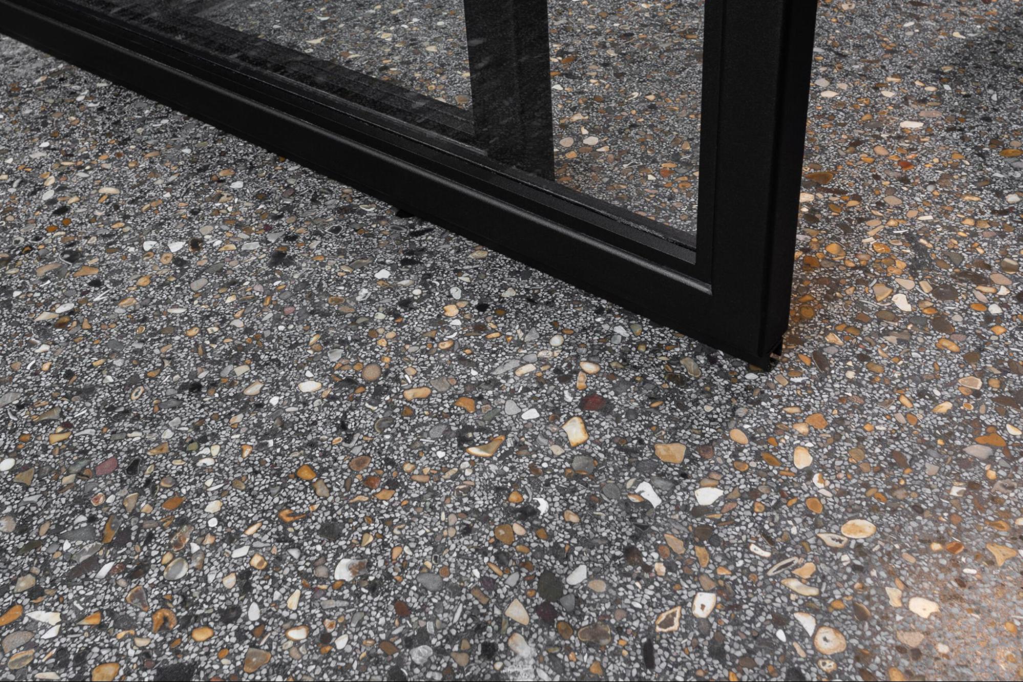 Donkere gietvloer met uitgesproken steentextuur voor een karaktervolle look