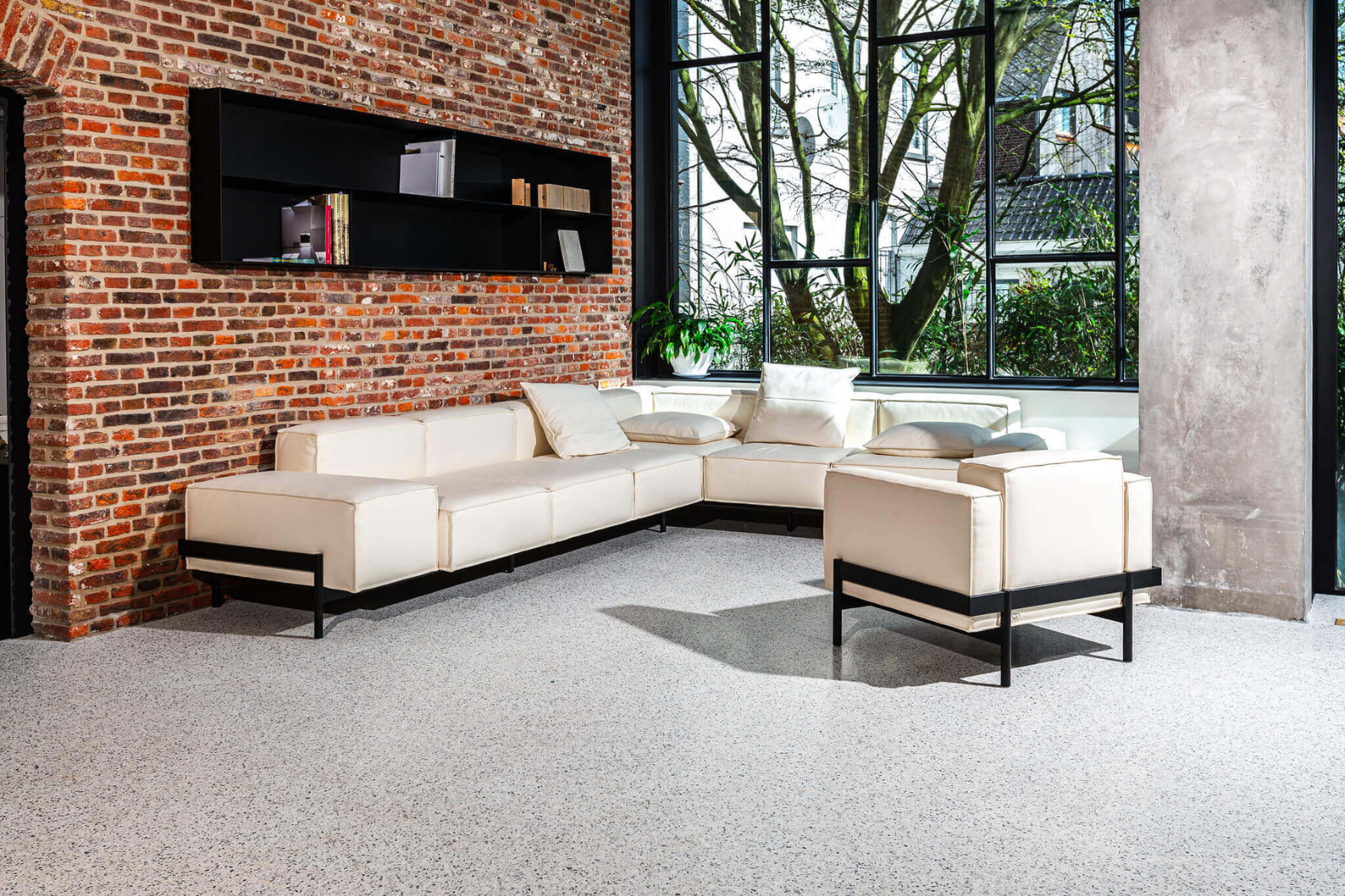 Moderne woonkamer met naadloze epoxy terrazzo gietvloer met marmerkorrels en lichte terrazzo afwerking.