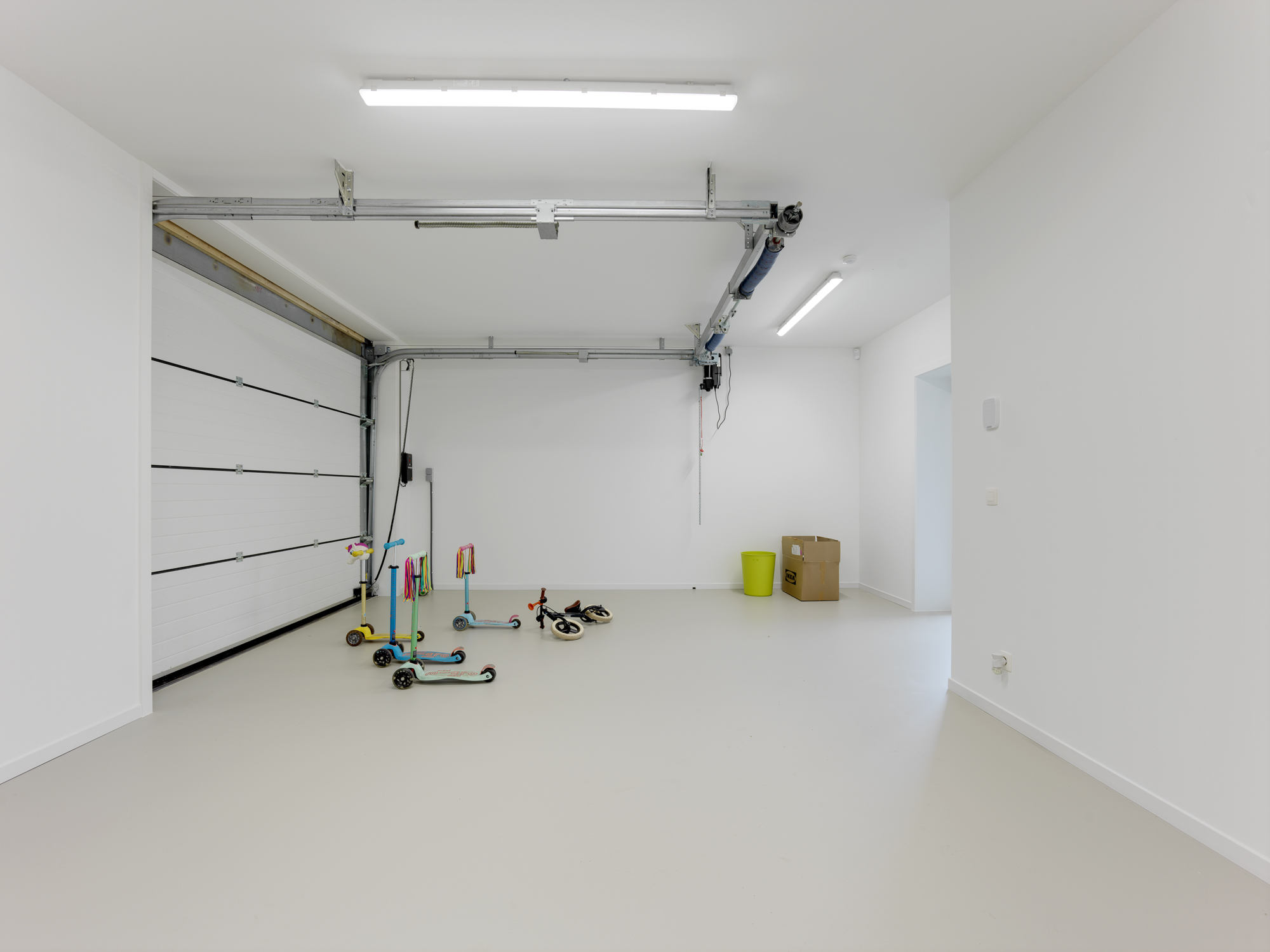 Ruime garage met strakke epoxy vloer en moderne, onderhoudsvriendelijke afwerking.