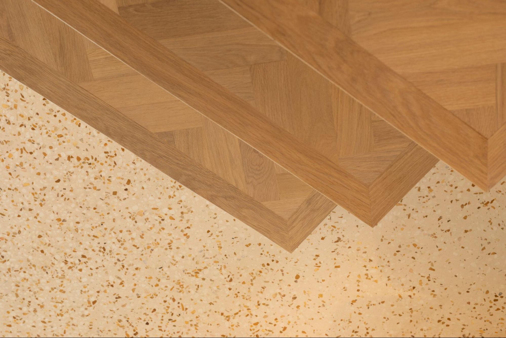 Lichte terrazzo gietvloer gecombineerd met warm hout voor een elegante afwerking