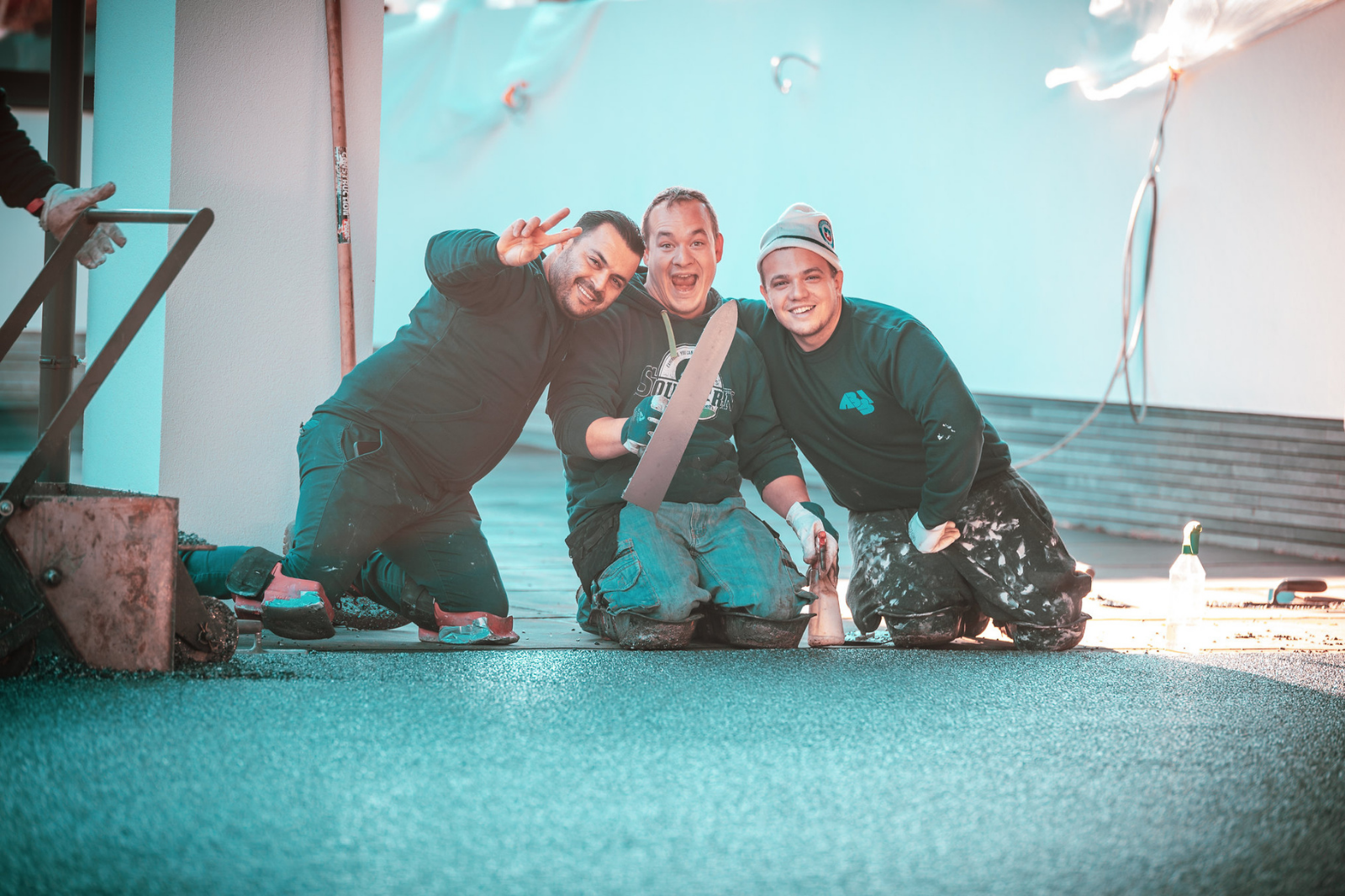 Ervaren vakmannen brengen een troffelvloer handmatig aan met troffel en precisie